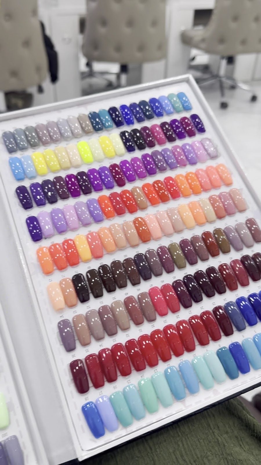 A wall display board of gel polish colour tips in rows of every shade